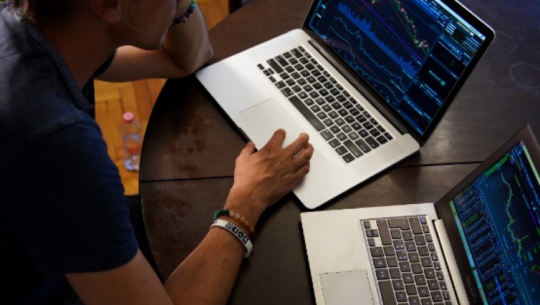 two laptops with on person sitting at a desk